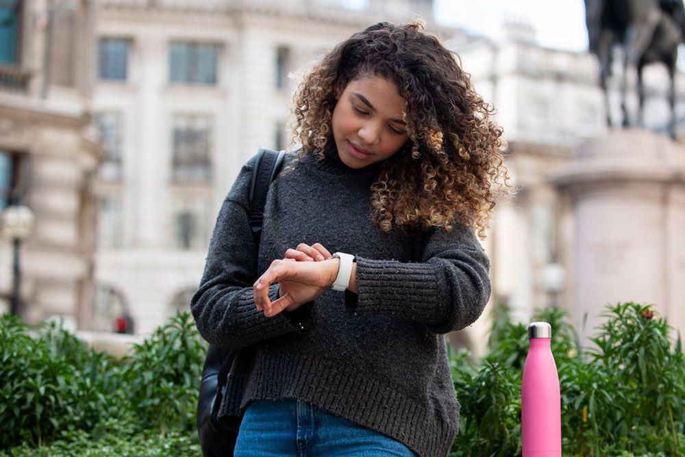 Woman checking her watch in the city